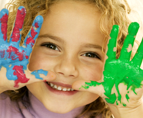 Smiling Girl with Hands Covered in Paint --- Image by © Royalty-Free/Corbis